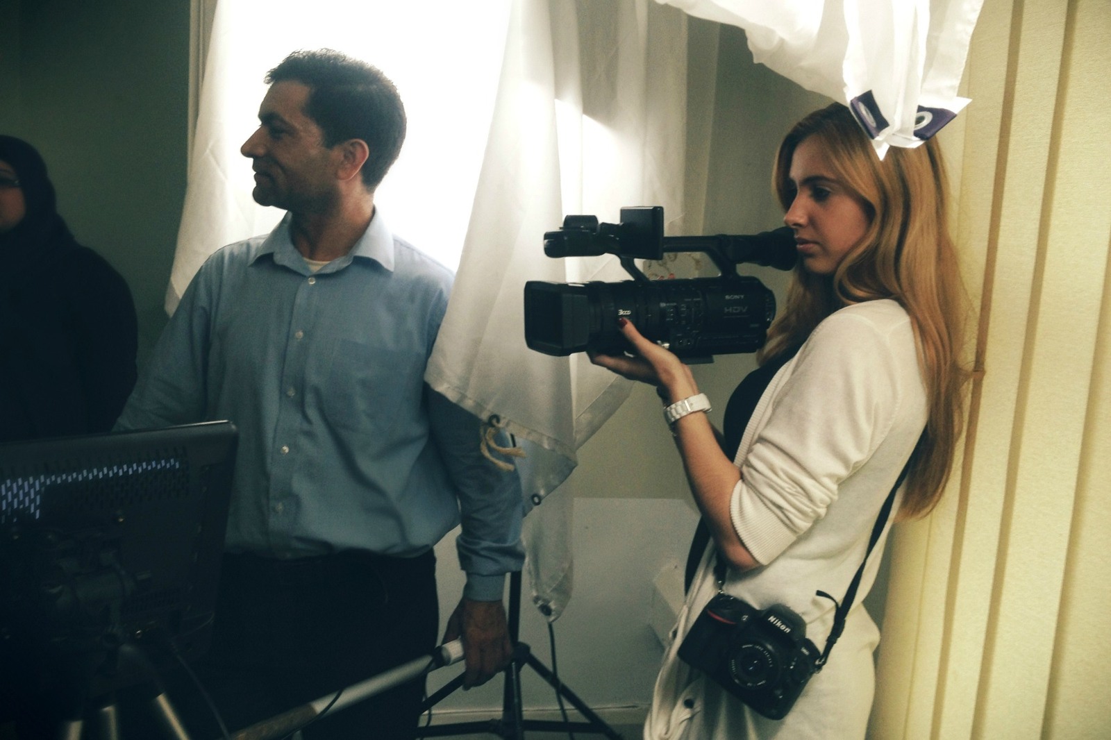 Mihaela on her first filmmaking job, holding a video camera with a stills camera around her shoulder