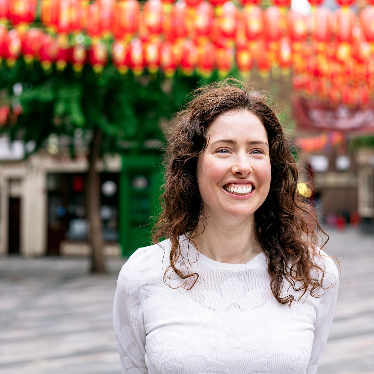 The Healing Hunter presenter smiling beneath Chinatown lanterns